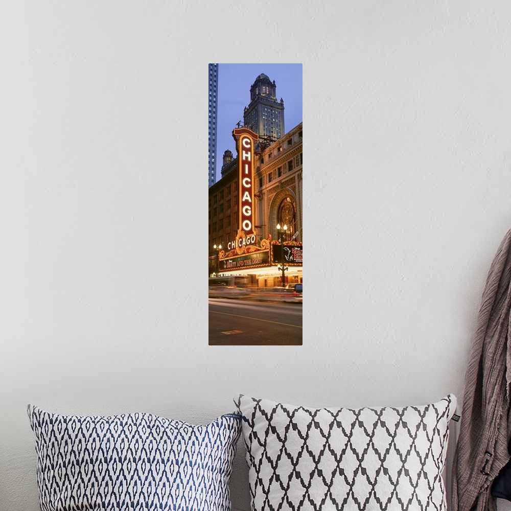 A bohemian room featuring Vertical panoramic photograph of downtown theater with lit up marquee.  There is a skyscraper in ...