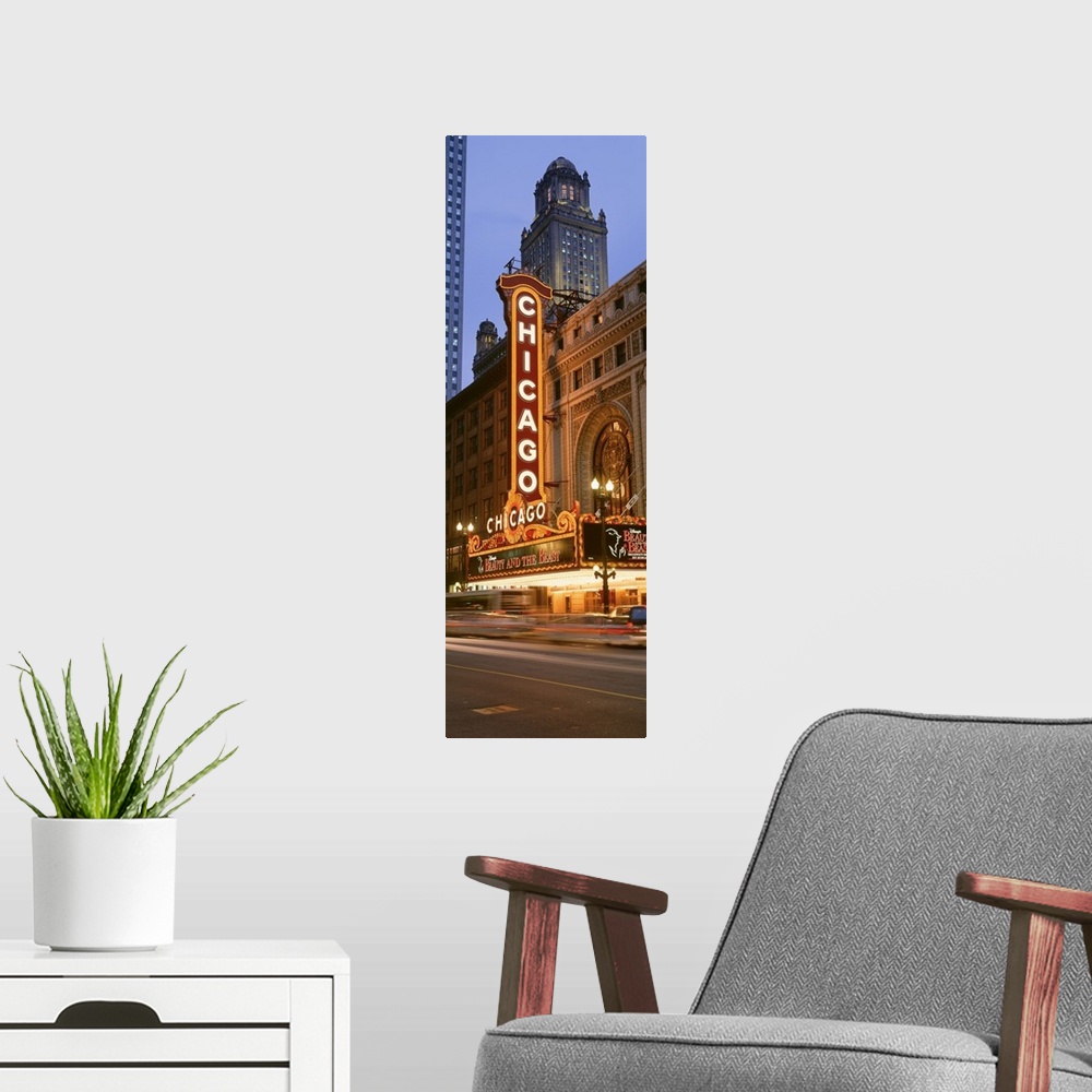 A modern room featuring Vertical panoramic photograph of downtown theater with lit up marquee.  There is a skyscraper in ...