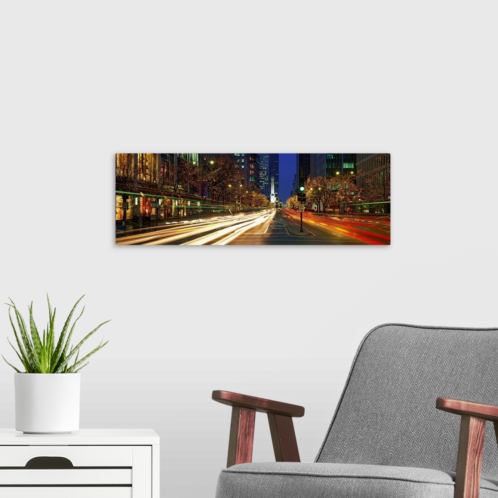 A modern room featuring Wide angle photograph looking down a city street of Chicago at night, the trees and storefronts l...