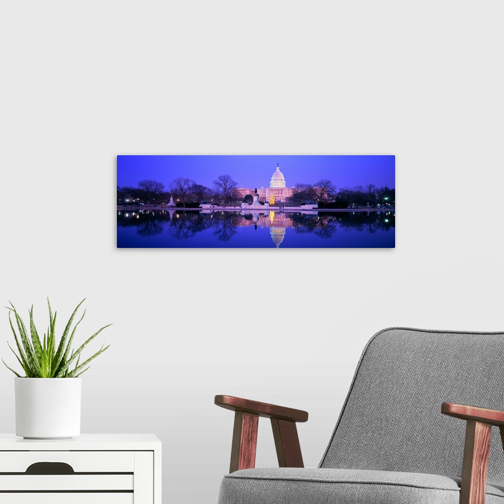 A modern room featuring A large panoramic photograph of the US Capitol building lit up during the night. The building and...