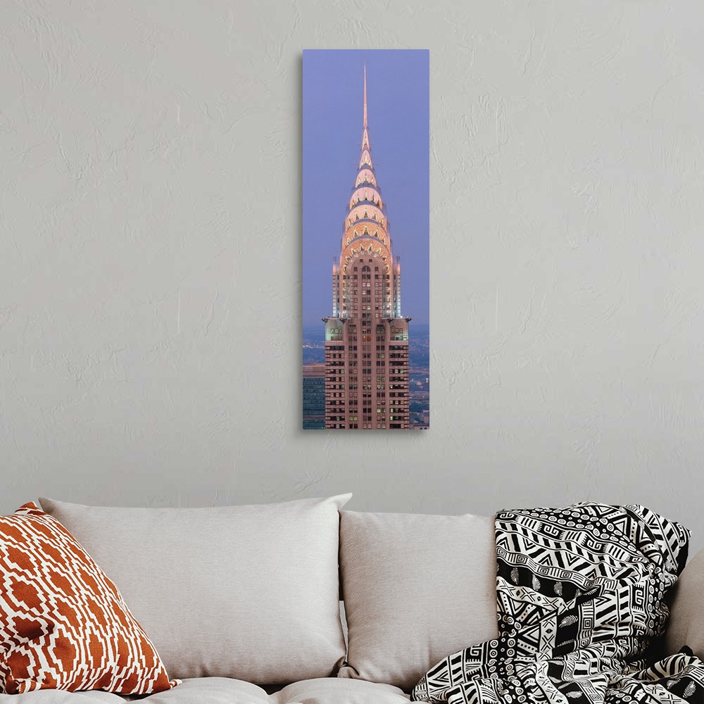 A bohemian room featuring Lit up spire and top floors of the Chrysler building at dusk.
