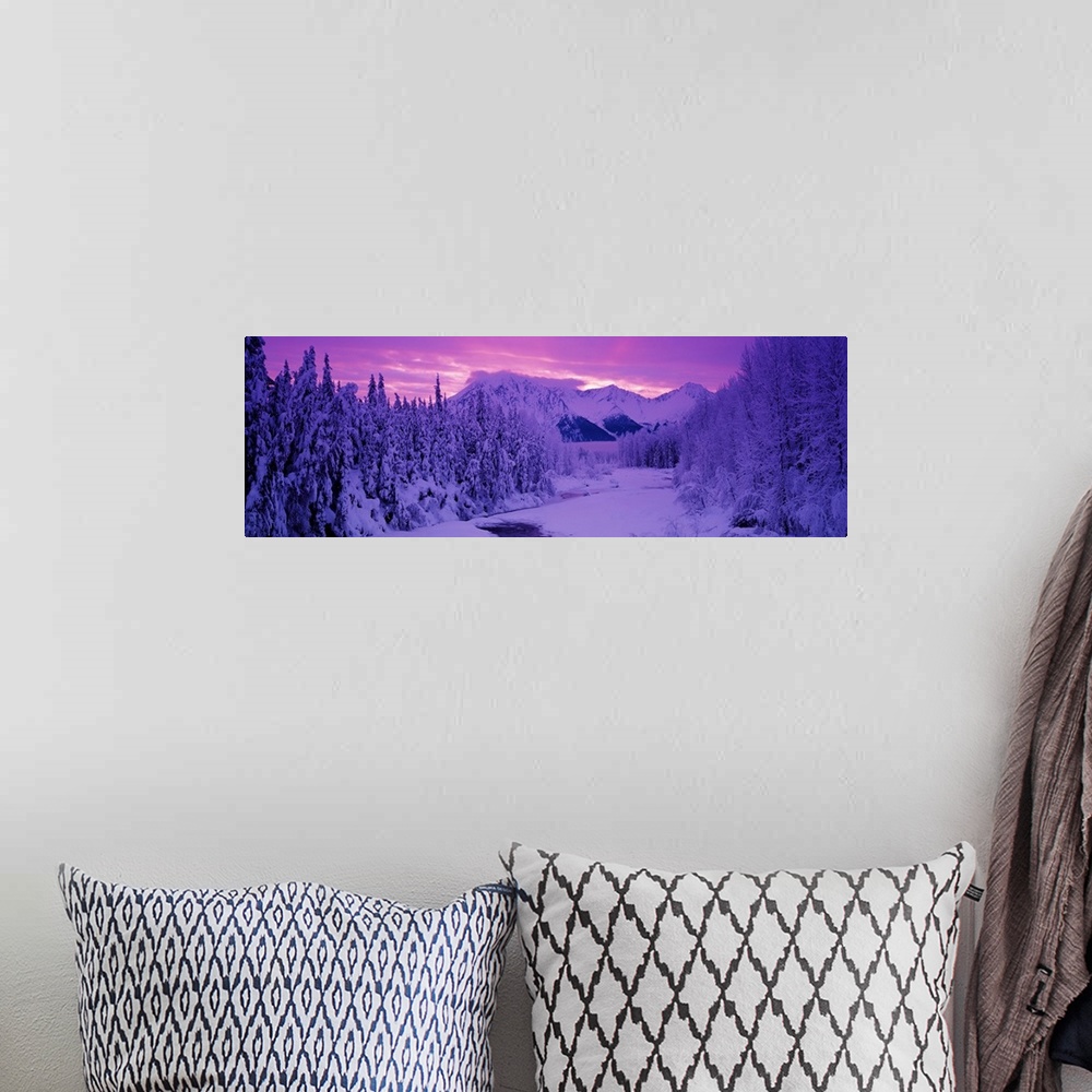 A bohemian room featuring Panoramic photo art of snow covered forests on the left and right of a snowy open space with a su...