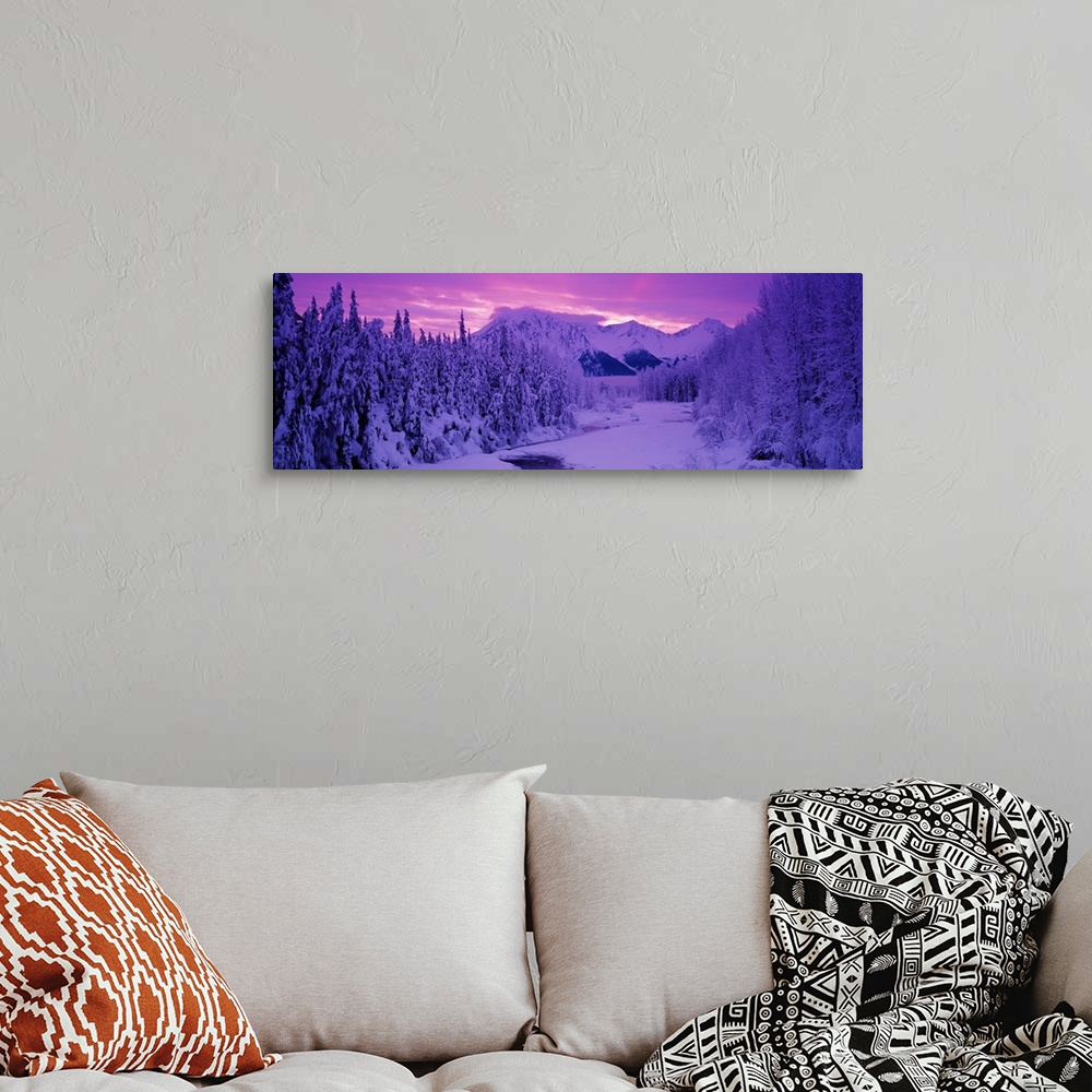 A bohemian room featuring Panoramic photo art of snow covered forests on the left and right of a snowy open space with a su...