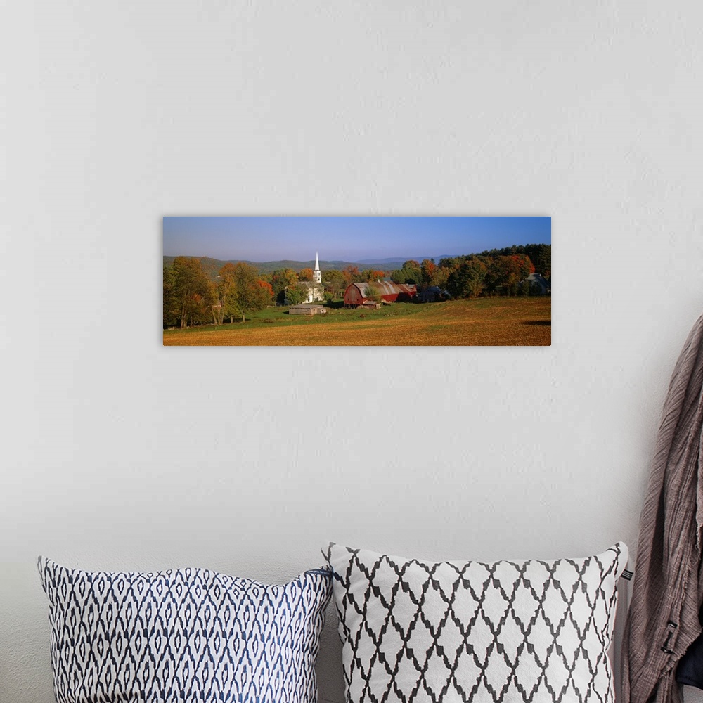 A bohemian room featuring This panoramic photograph is of a barn and a church surrounded by autumn trees with large hills i...