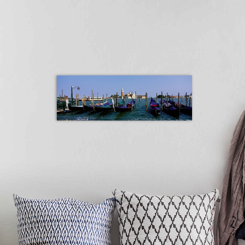 A bohemian room featuring Long photo on canvas of gondolas parked  near posts in Italy.