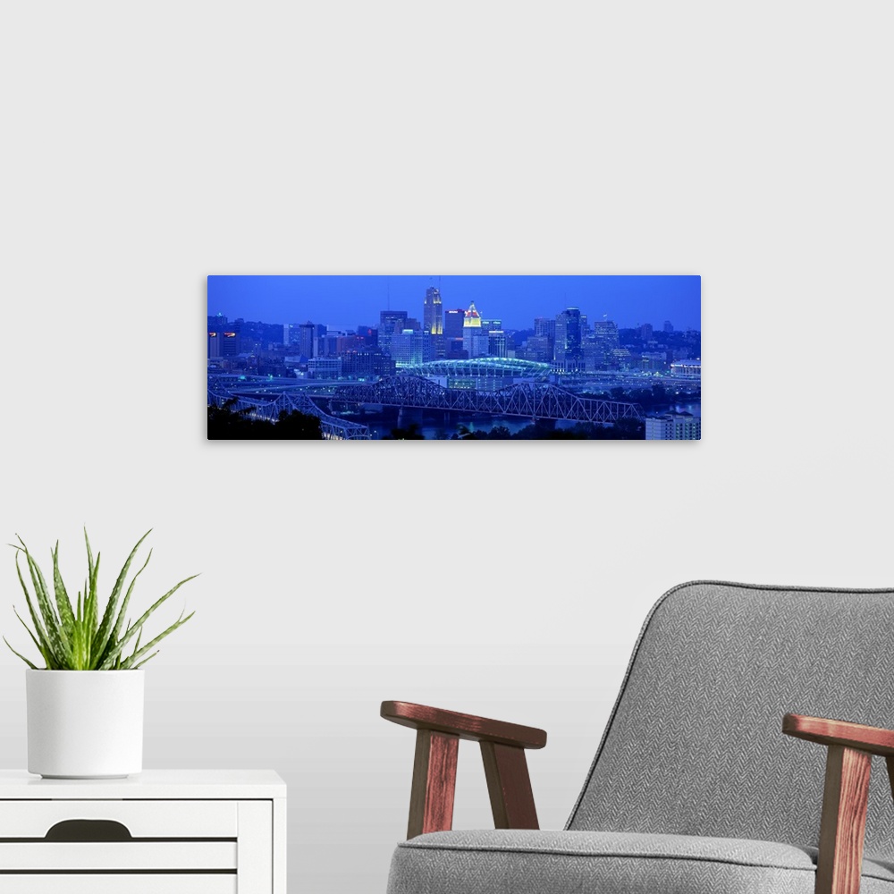 A modern room featuring Panoramic photograph of downtown  Cincinnati skyline at night and bridges over the Ohio River.