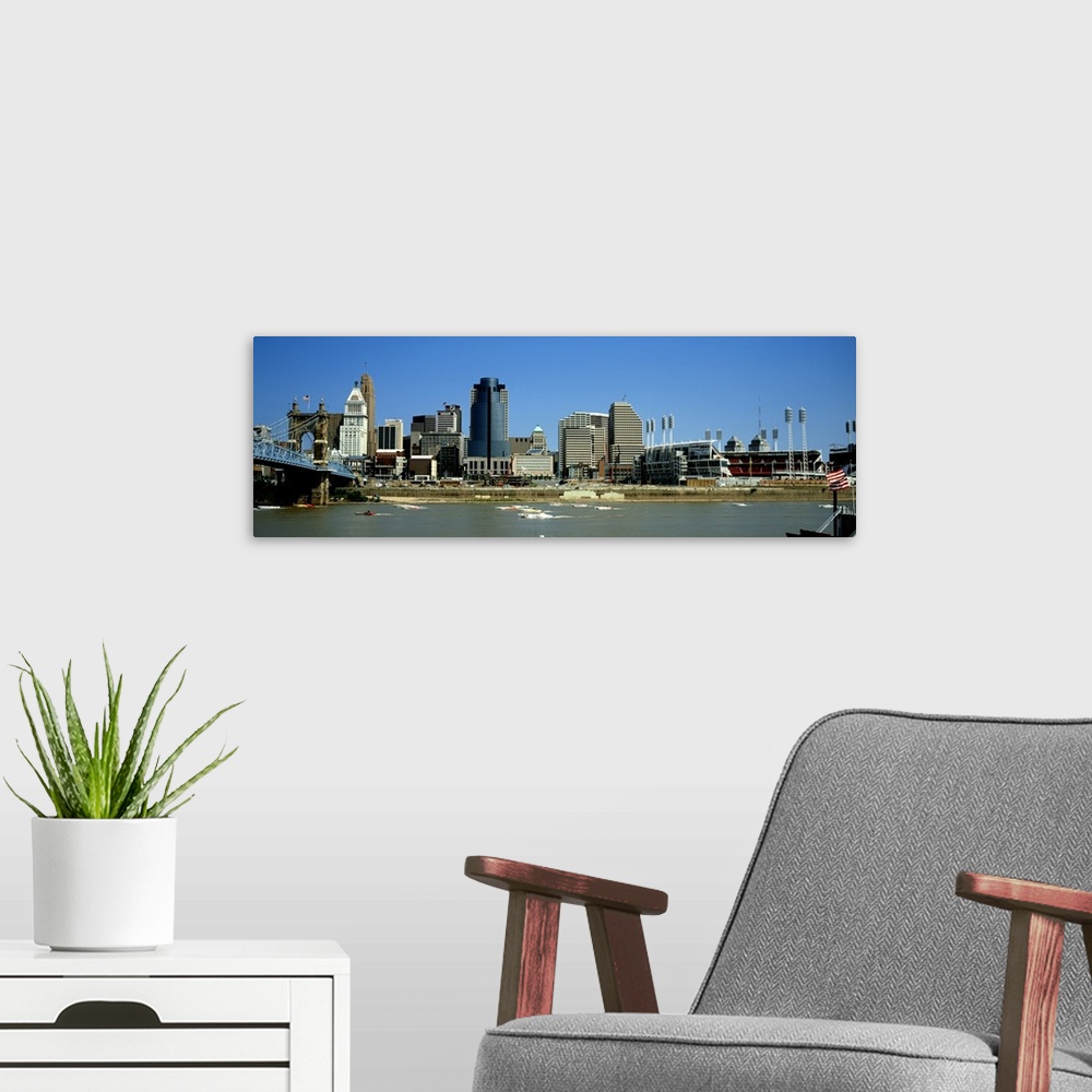 A modern room featuring Boats skimming along the Ohio River with downtown Cincinnati in the background.