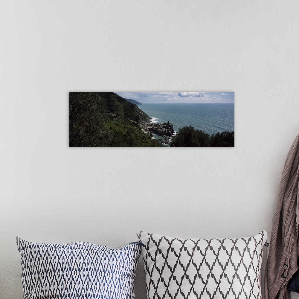 A bohemian room featuring Panoramic image of an Italian cliff leading to a city by the ocean on canvas.