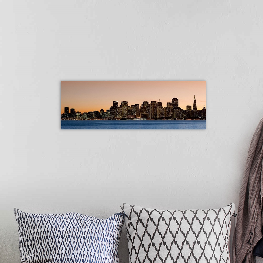 A bohemian room featuring Horizontal image on canvas of the San Francisco skyline lit up at sunset by the water.