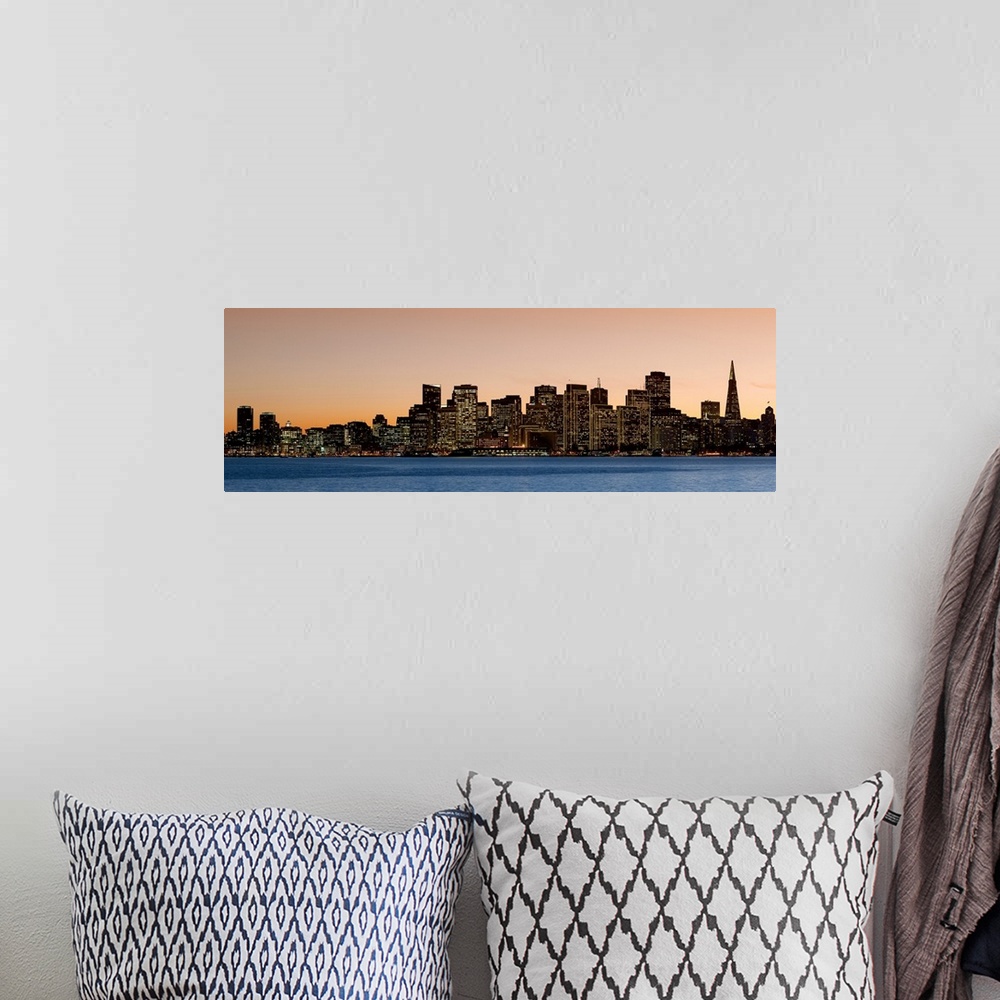 A bohemian room featuring Horizontal image on canvas of the San Francisco skyline lit up at sunset by the water.