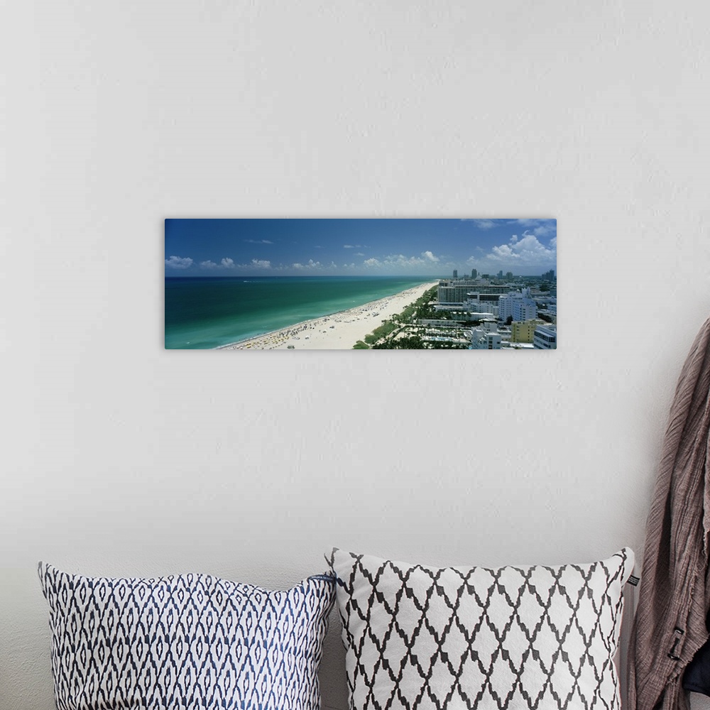 A bohemian room featuring An aerial photograph is taken of the coast in Miami showing a busy beach lined by the teal ocean ...