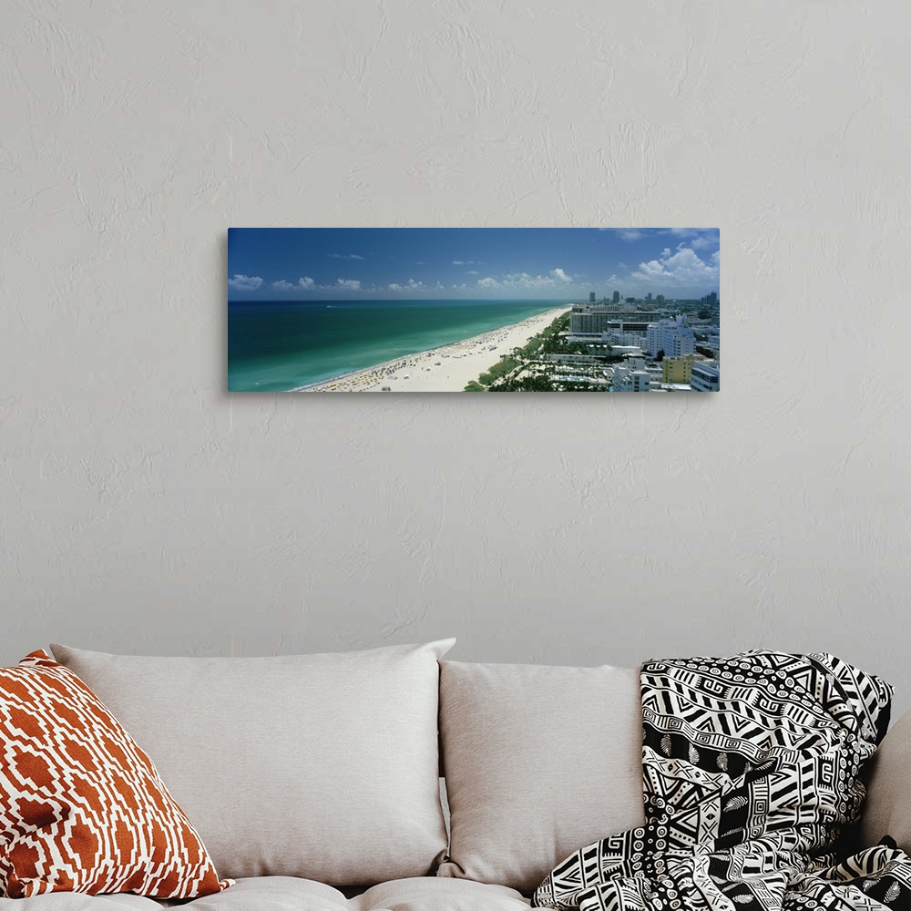 A bohemian room featuring An aerial photograph is taken of the coast in Miami showing a busy beach lined by the teal ocean ...