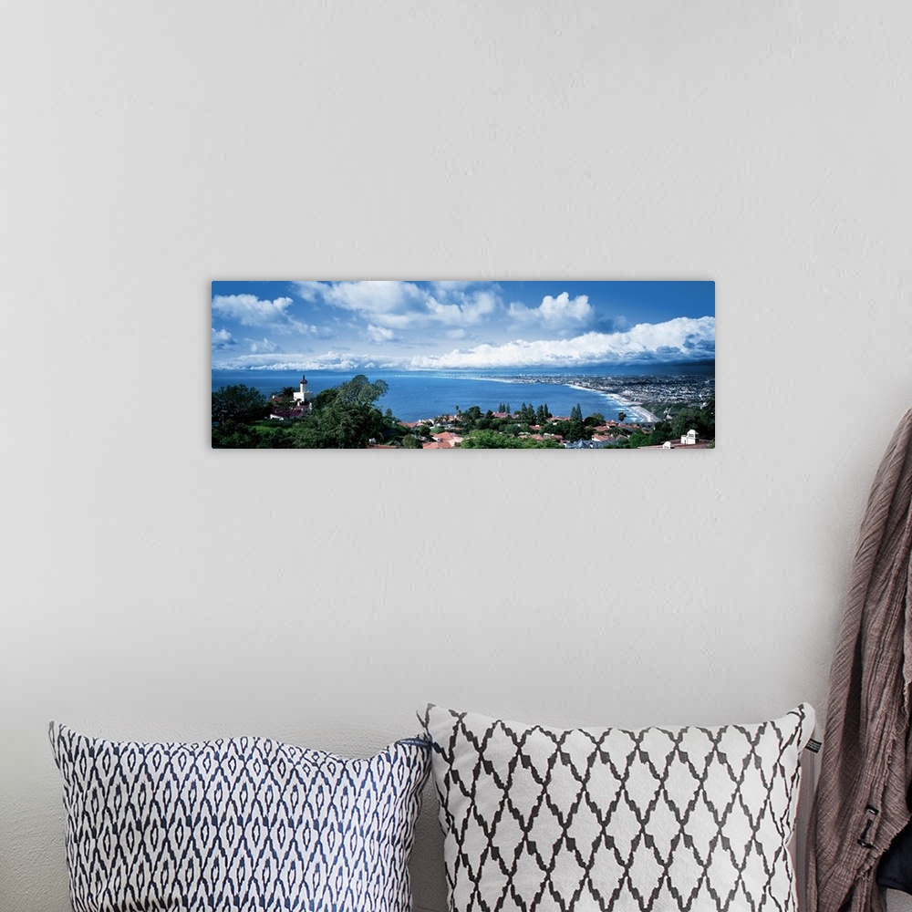 A bohemian room featuring Large panoramic print of a city along the Pacific Ocean with big billowing clouds in the distance.