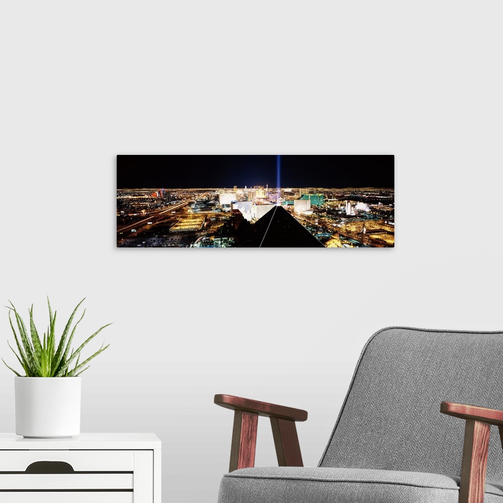 A modern room featuring Giant, wide angle landscape photograph of Las Vegas at night, taken looking downward from Mandala...