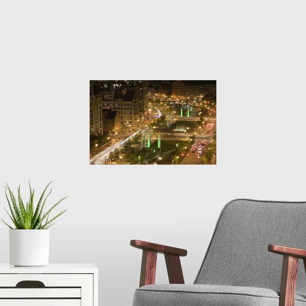 A modern room featuring A time lapsed photograph of busy metropolitan streets on either side of a hybrid park and median ...