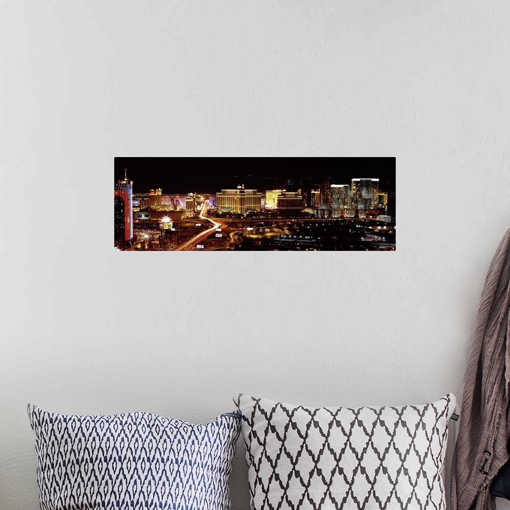 A bohemian room featuring A time lapsed photograph of a car lights streaming through the city road ways with the all the li...