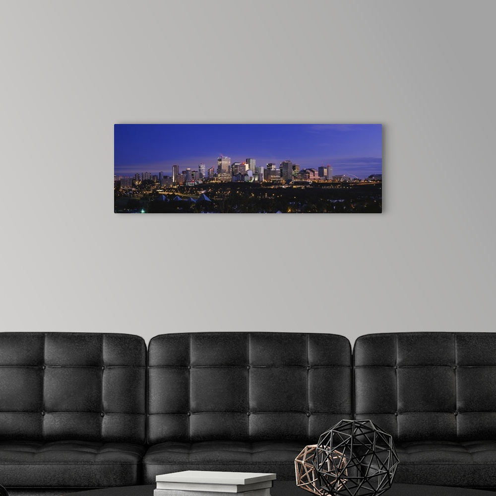 A modern room featuring Panoramic photograph of cityscape at dusk with buildings and skyscrapers lit up.