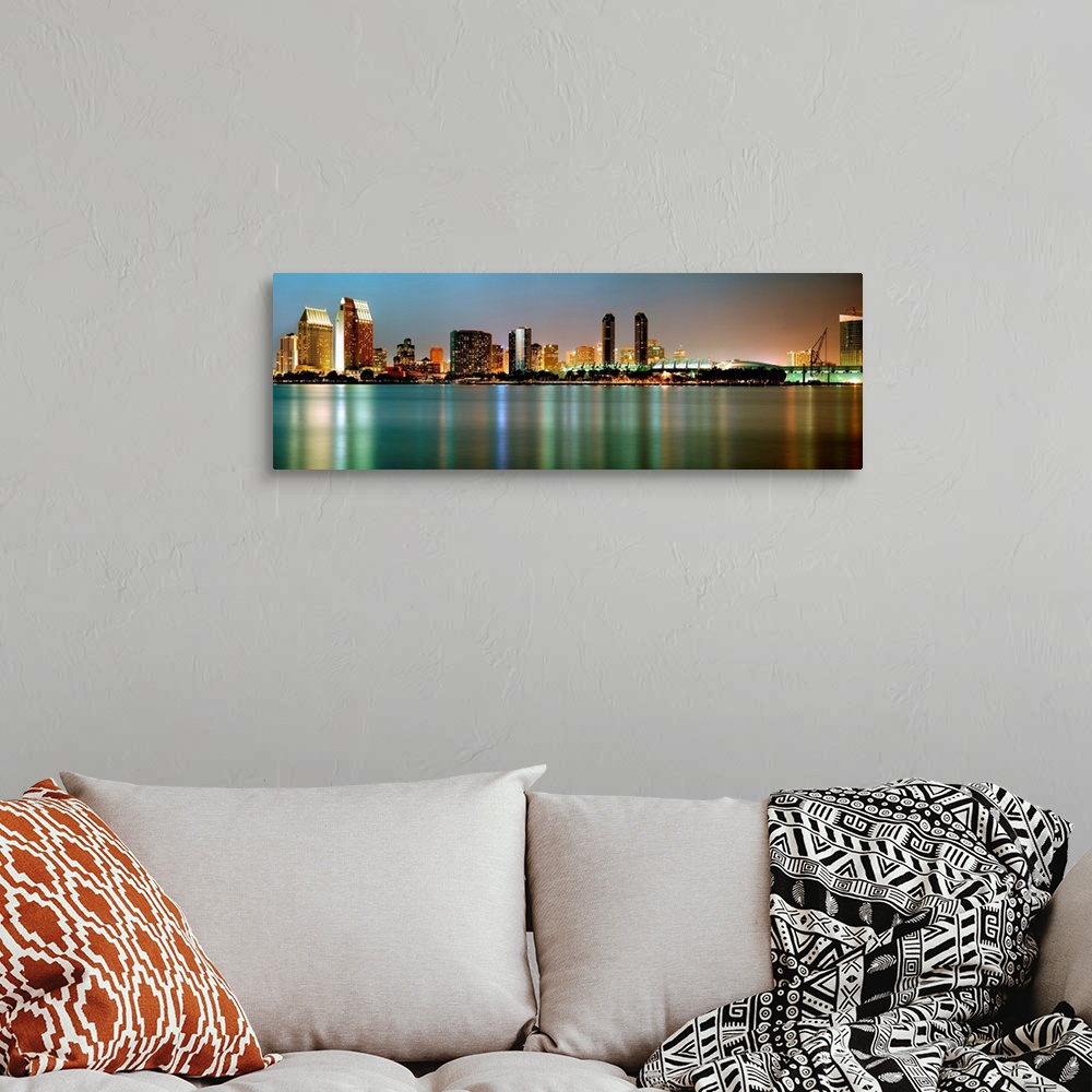 A bohemian room featuring City lights reflect in still waters of the cityscape panoramic wall art.