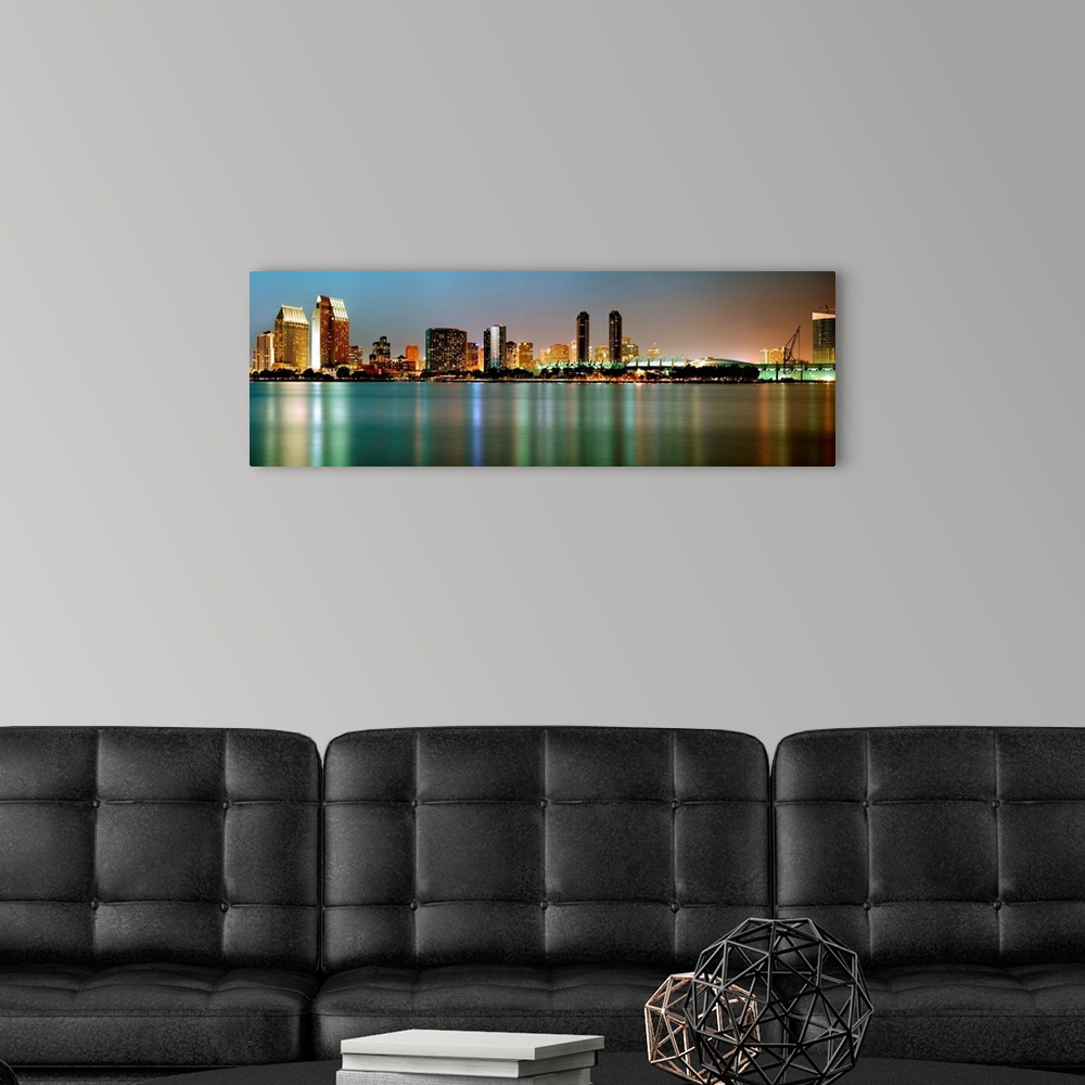 A modern room featuring City lights reflect in still waters of the cityscape panoramic wall art.