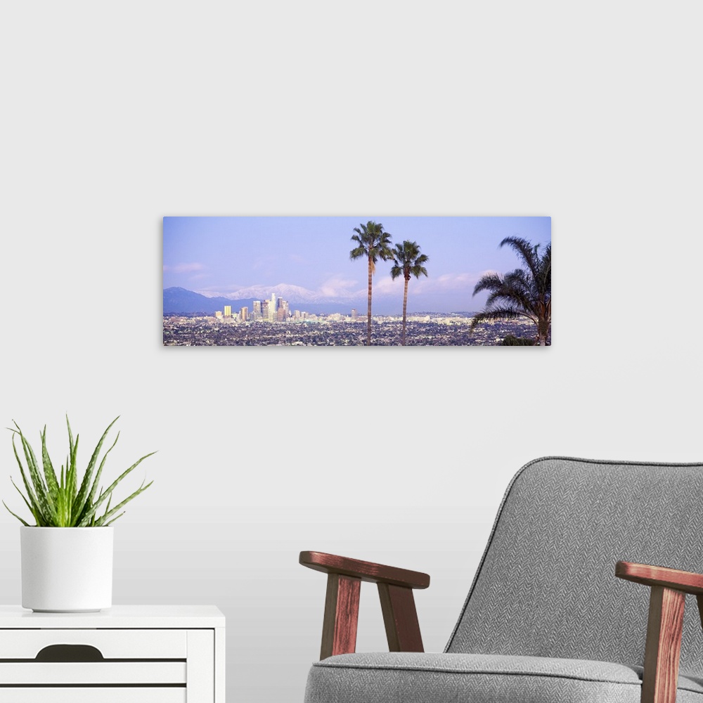 A modern room featuring Panoramic photograph of west coast city skyline with mountains in the distance and palm trees in ...