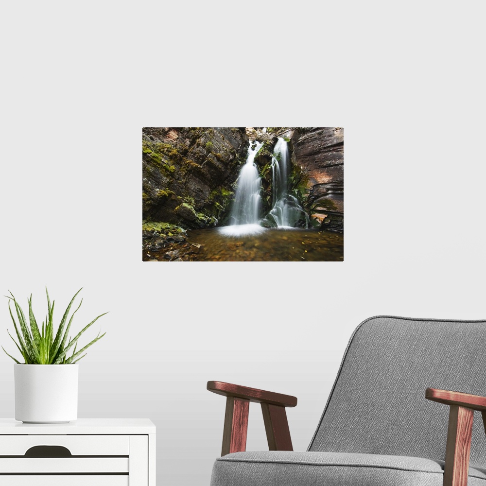 A modern room featuring Photo on canvas of water falling from a rocky cliff into a pool of water in Montana.