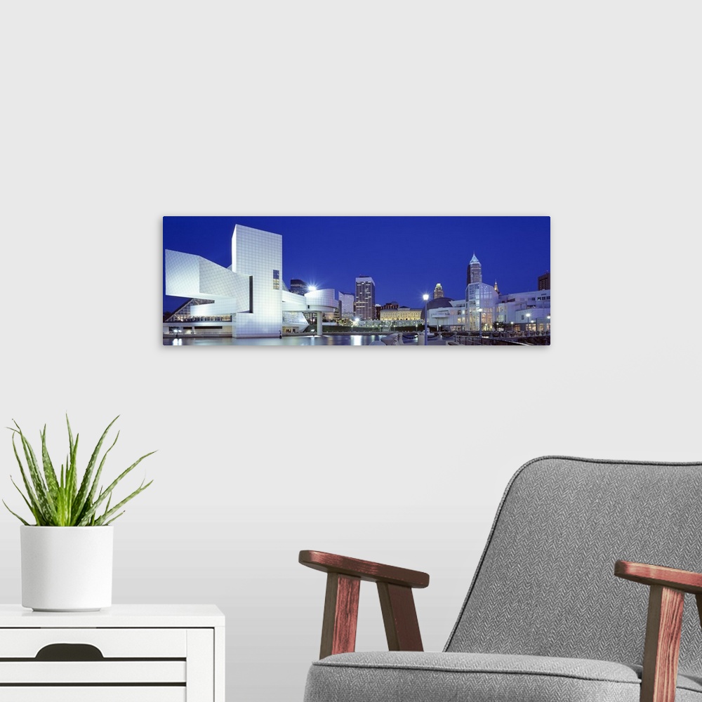 A modern room featuring Panoramic photo on canvas of a modern styled building in the foreground and a cityscape in the di...
