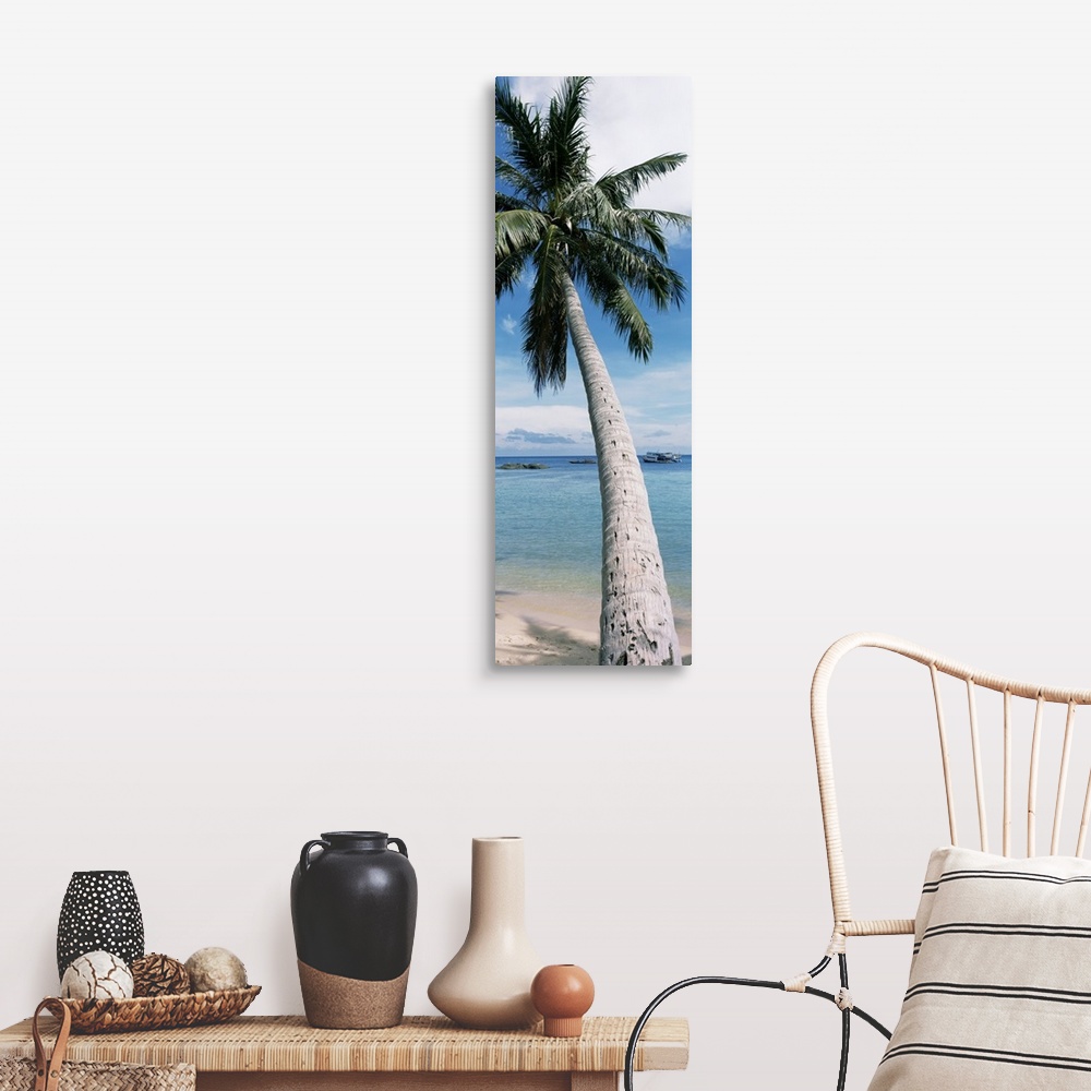 A farmhouse room featuring A vertical, panoramic shaped canvas of a single tree in front of a tropical ocean and anchored boat.