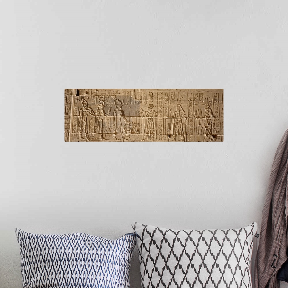 A bohemian room featuring Wide photo on canvas of Egyptian hieroglyphics carved into a rock wall.