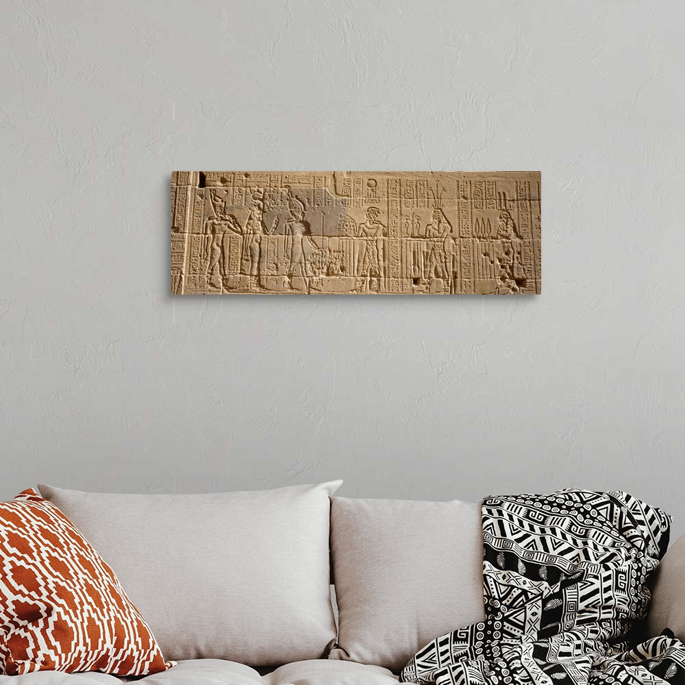 A bohemian room featuring Wide photo on canvas of Egyptian hieroglyphics carved into a rock wall.