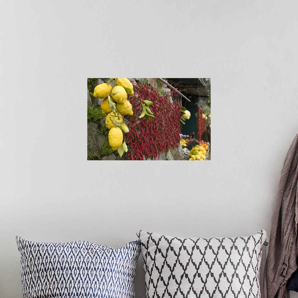 A bohemian room featuring Lemons and chili peppers in Italy hang for sale in a local farmers market.
