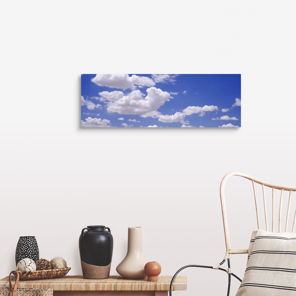 A farmhouse room featuring Giant, landscape photograph of a light blue sky with large, fluffy, white clouds.