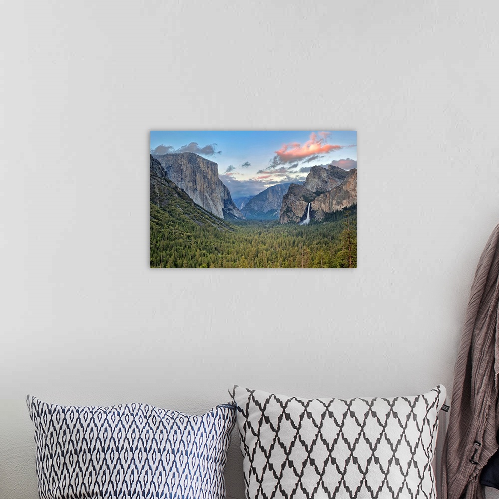 A bohemian room featuring Landscape photograph on a big canvas of Yosemite Valley, green tree tops surrounded by mountains,...