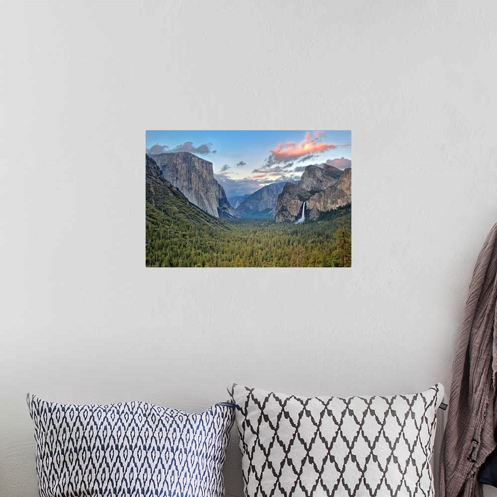 A bohemian room featuring Landscape photograph on a big canvas of Yosemite Valley, green tree tops surrounded by mountains,...
