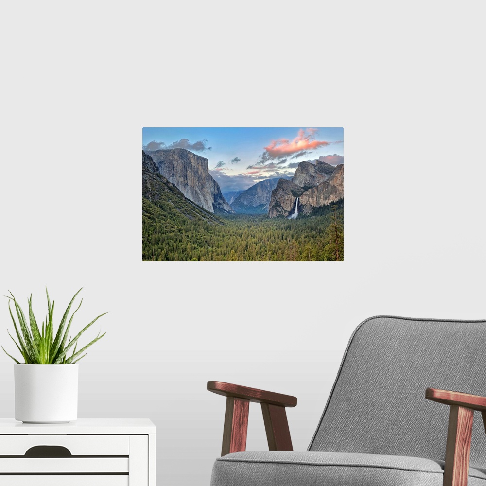 A modern room featuring Landscape photograph on a big canvas of Yosemite Valley, green tree tops surrounded by mountains,...