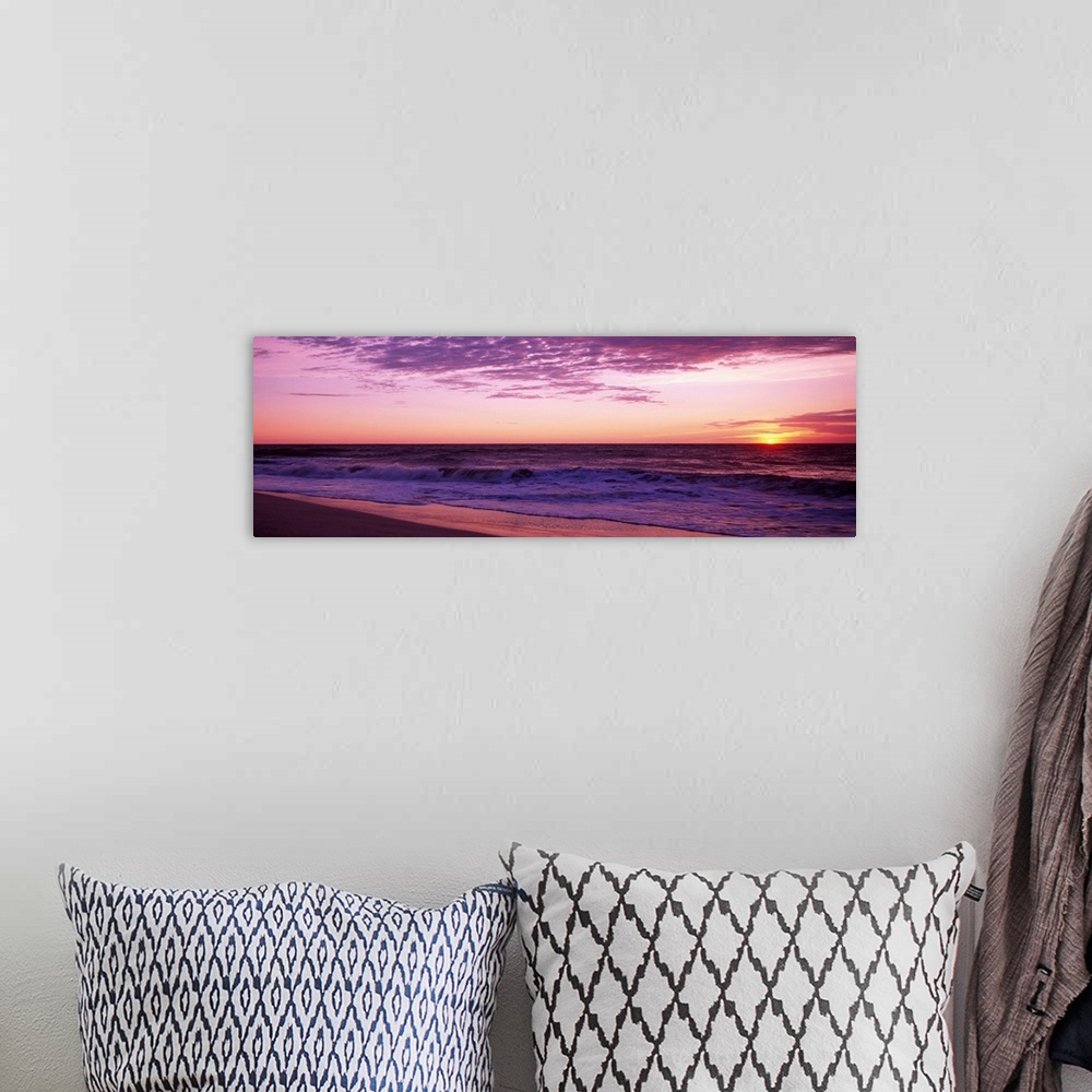 A bohemian room featuring Small waves washing up on shore as the sunrises in this landscape photograph.