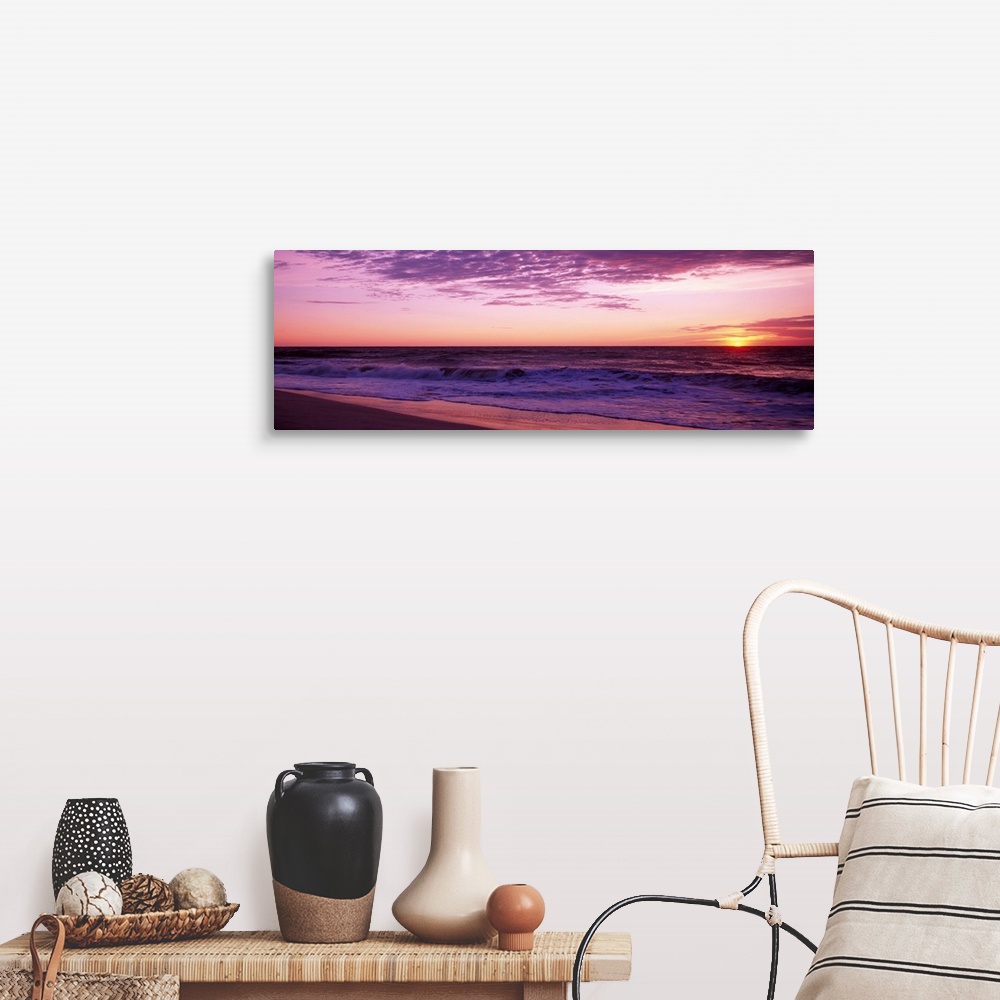 A farmhouse room featuring Small waves washing up on shore as the sunrises in this landscape photograph.
