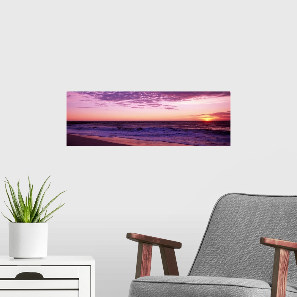A modern room featuring Small waves washing up on shore as the sunrises in this landscape photograph.