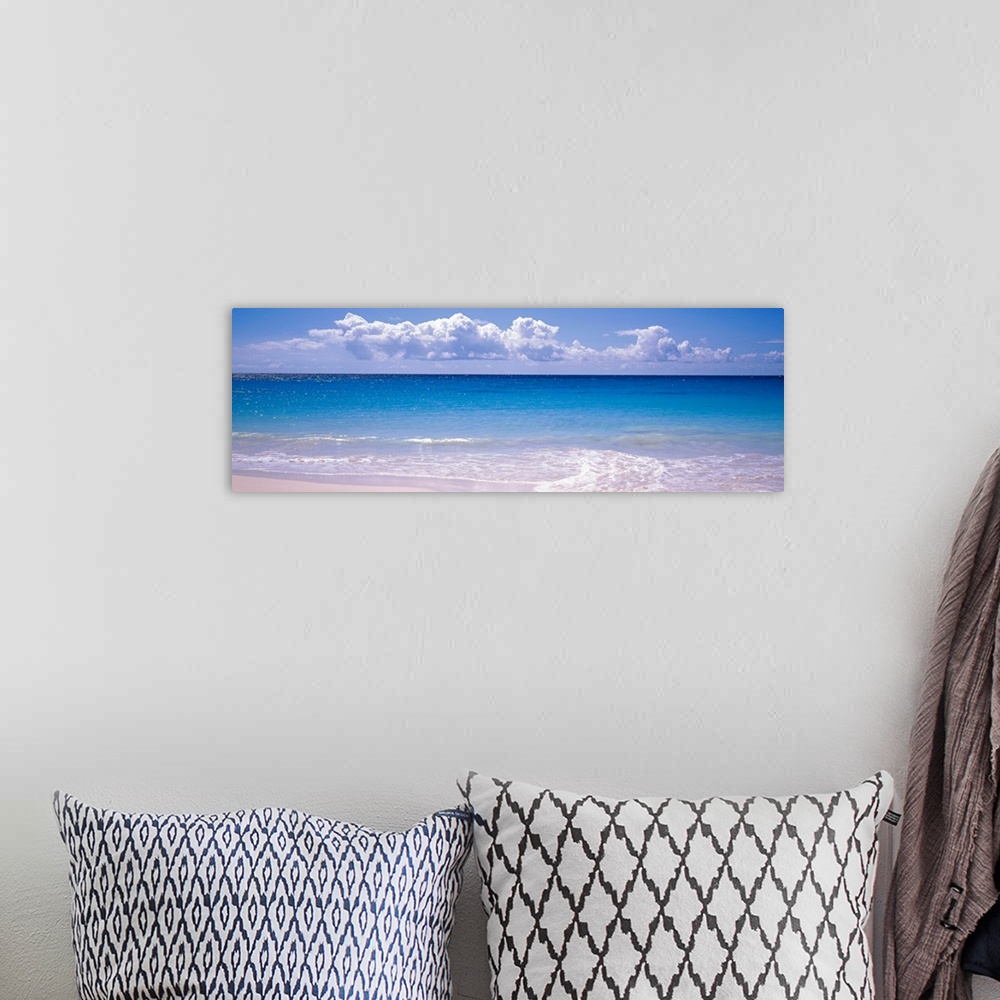 A bohemian room featuring Panoramic photograph shows the sparkly water of an ocean slowly coming into shore on a bright and...