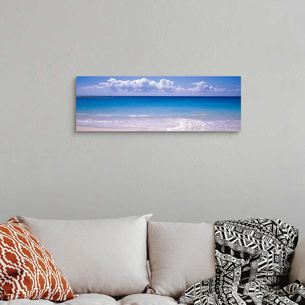 A bohemian room featuring Panoramic photograph shows the sparkly water of an ocean slowly coming into shore on a bright and...