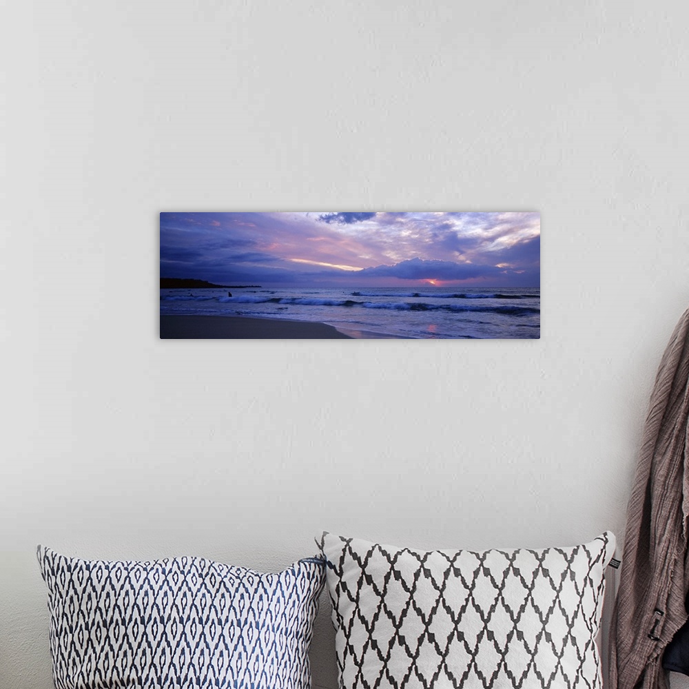 A bohemian room featuring This big picture is a panoramic photograph of the ocean surf sweeping over the shore. The sun fil...
