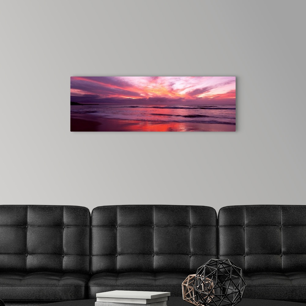 A modern room featuring Panoramic photograph taken of a lively sunset over Hapuna Beach in Big Island, Hawaii.  In the fo...