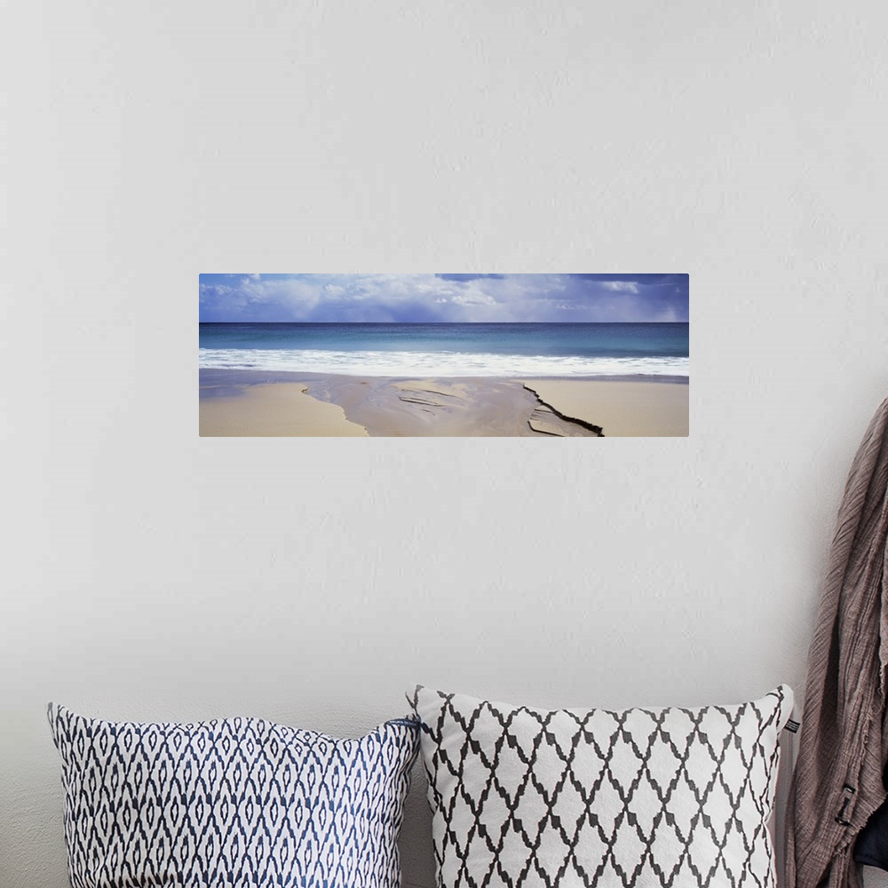A bohemian room featuring Wide angle shot from a deserted beach looking out onto the ocean under a cloudy sky.