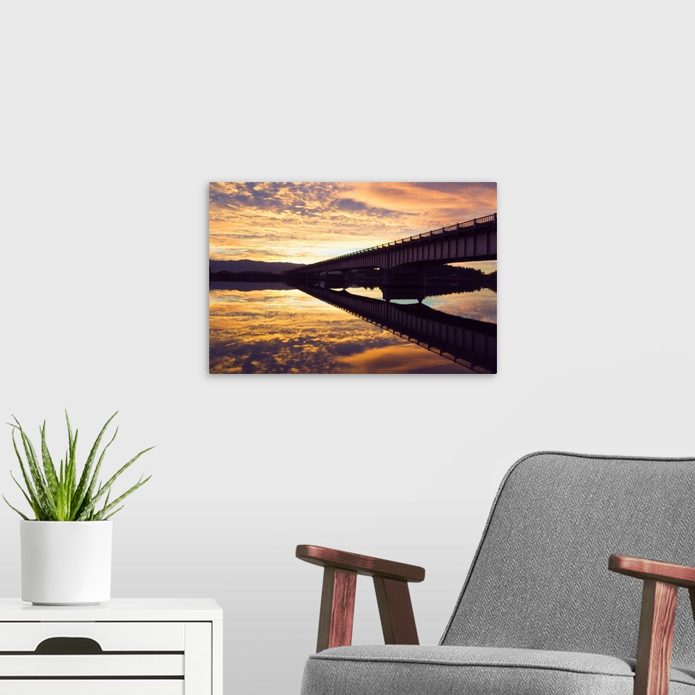 A modern room featuring Cloudy sunset sky over bridge, reflection in Flathead River, Montana