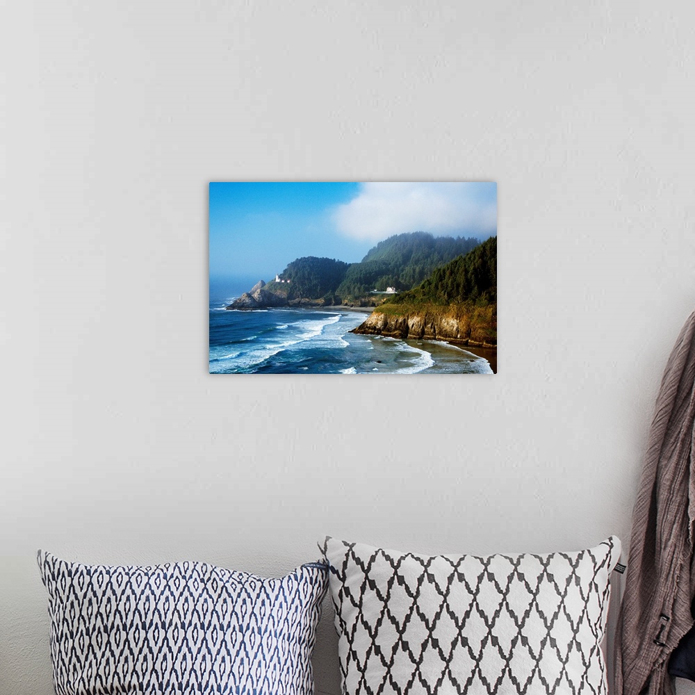 A bohemian room featuring This landscape photograph shows waves striking against rocky sea cliffs covered with conifer tree...