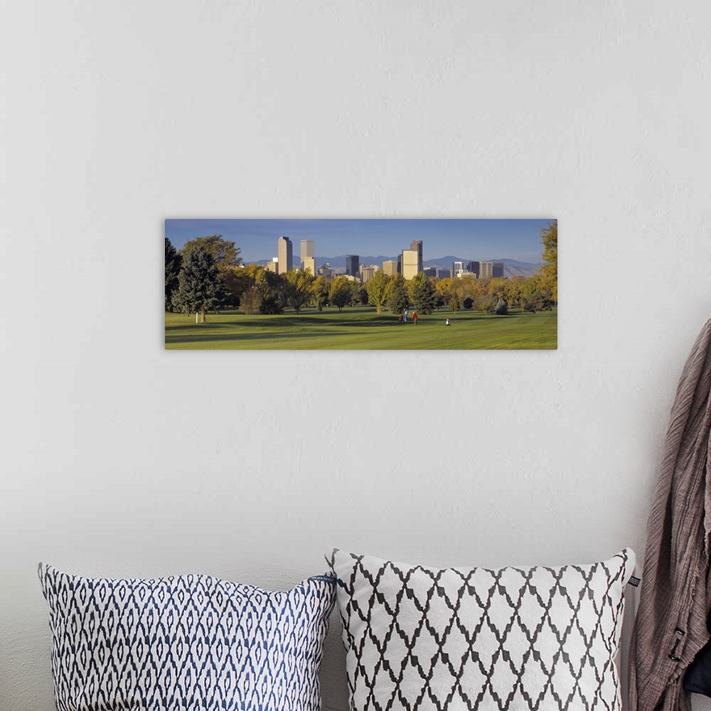 A bohemian room featuring Big, panoramic photograph on the green of a golf course in Colorado, full of trees, the buildings...