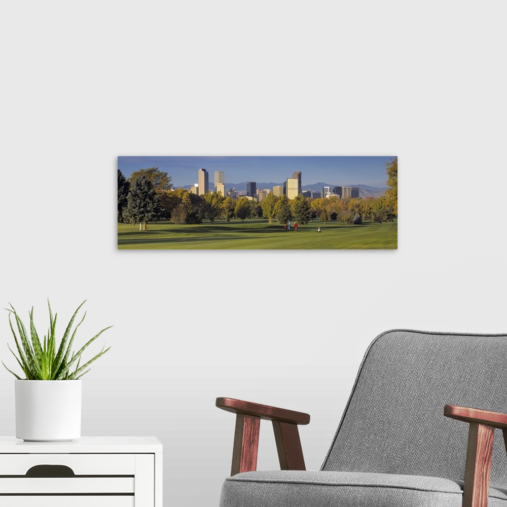 A modern room featuring Big, panoramic photograph on the green of a golf course in Colorado, full of trees, the buildings...
