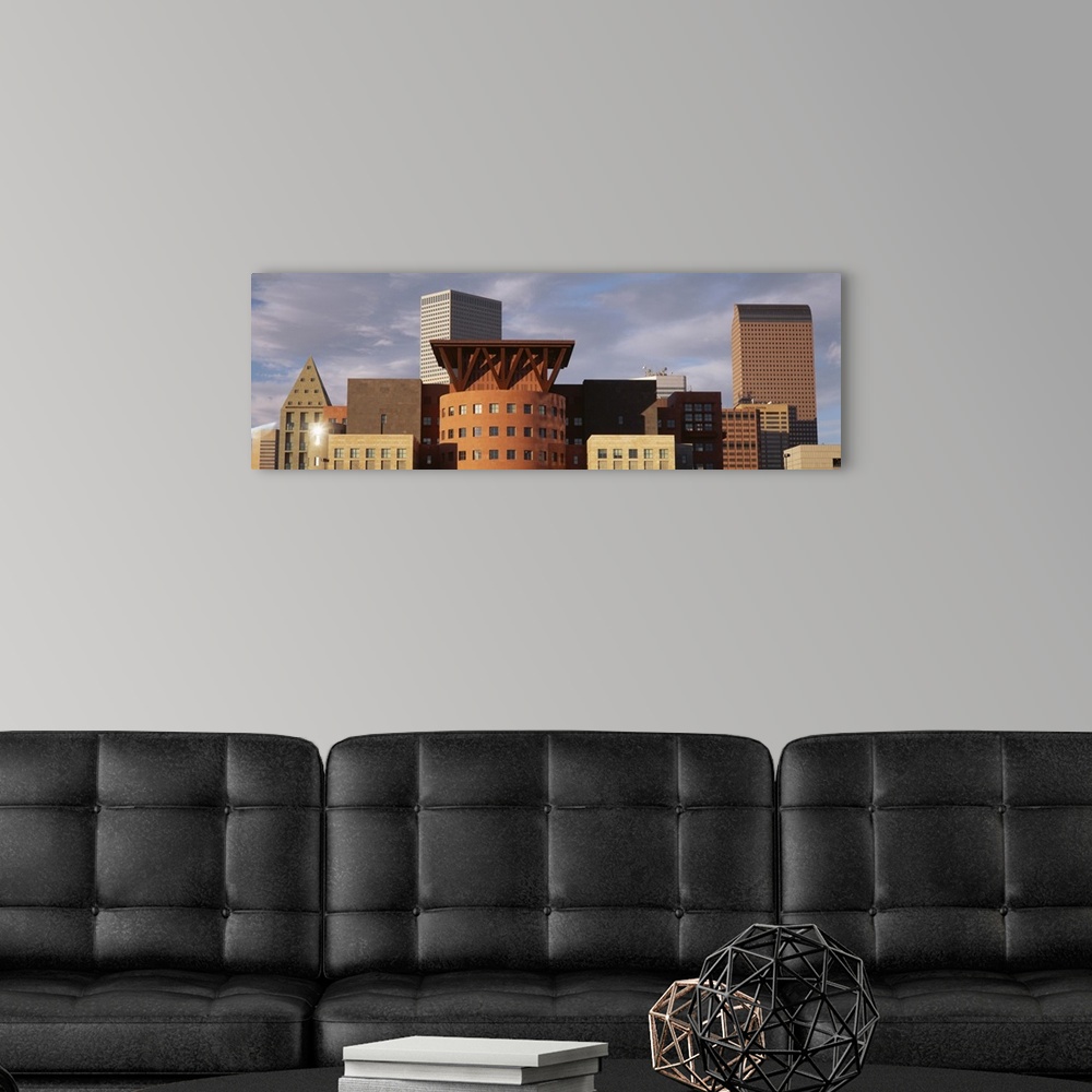 A modern room featuring Big, horizontal, close up photograph of the tops of skyscrapers in Denver, Colorado, against a mo...