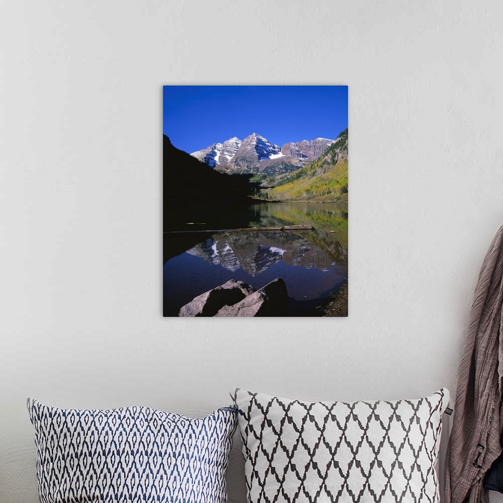 A bohemian room featuring Calm photograph of snowy mountain peaks in the Rocky Mountains, reflected in a still lake of fres...