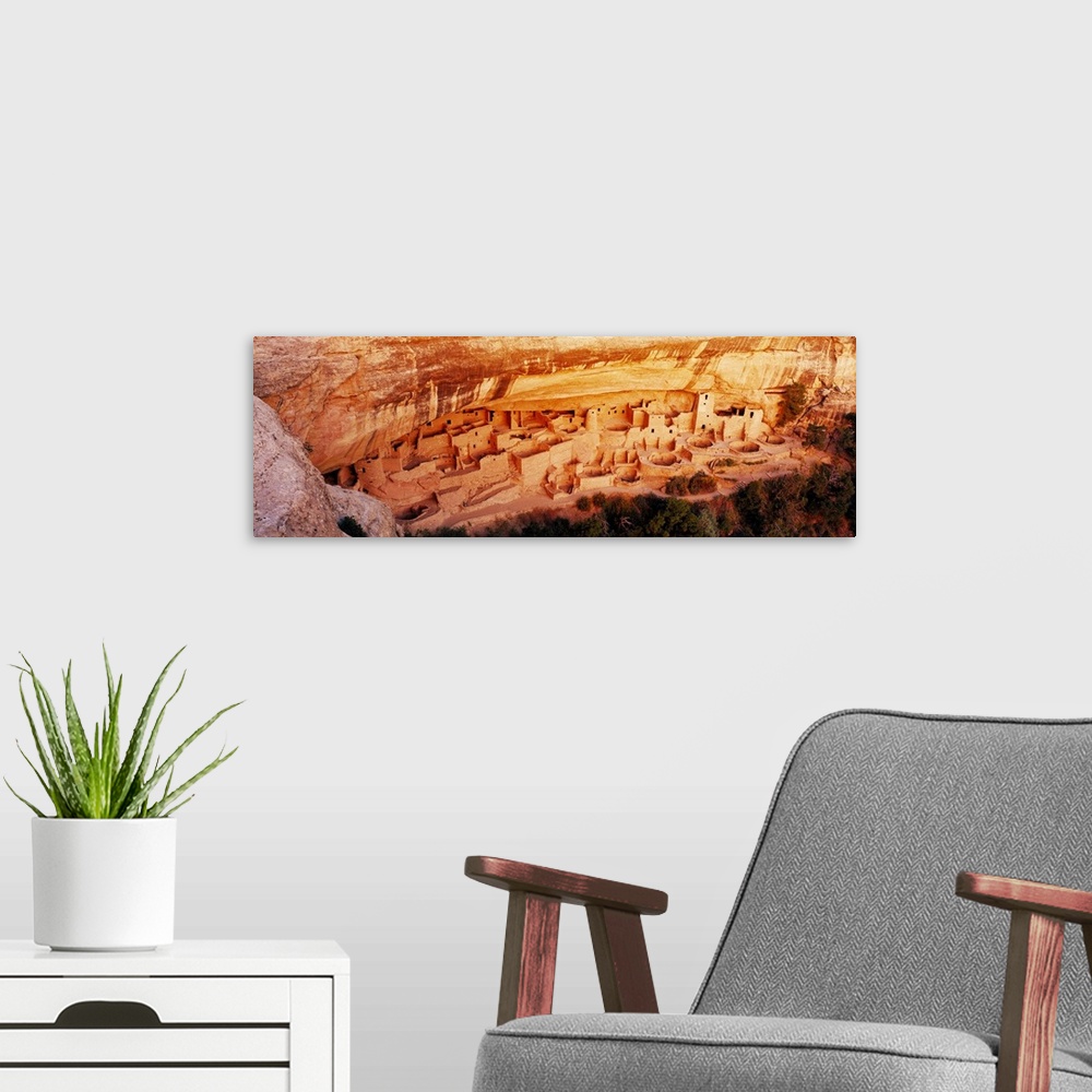 A modern room featuring This panoramic vista looks down into the cliff dwellings of the ancient Pueblo people as the ston...