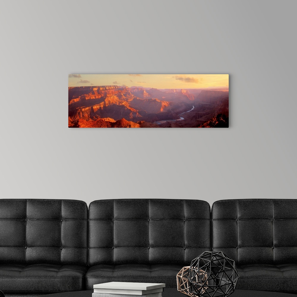 A modern room featuring Panoramic photograph of gorge with a stream running through the base.  There is fog with only a f...